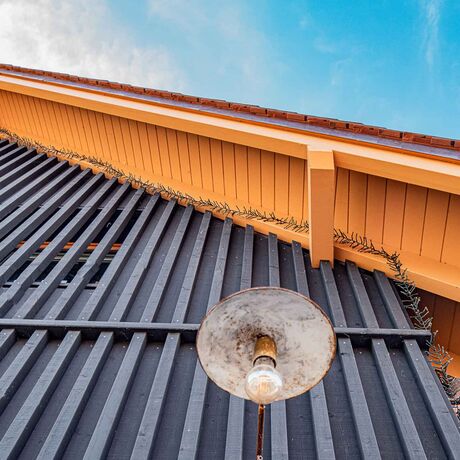 Gebr. Eisenring AG, 5-0216, Fassade, nord. Fichte, Schirmbretter 20/140 und Deckleisten 50/50, sägeroh, mineralische Farbe Farbton 9008 (schwarz)